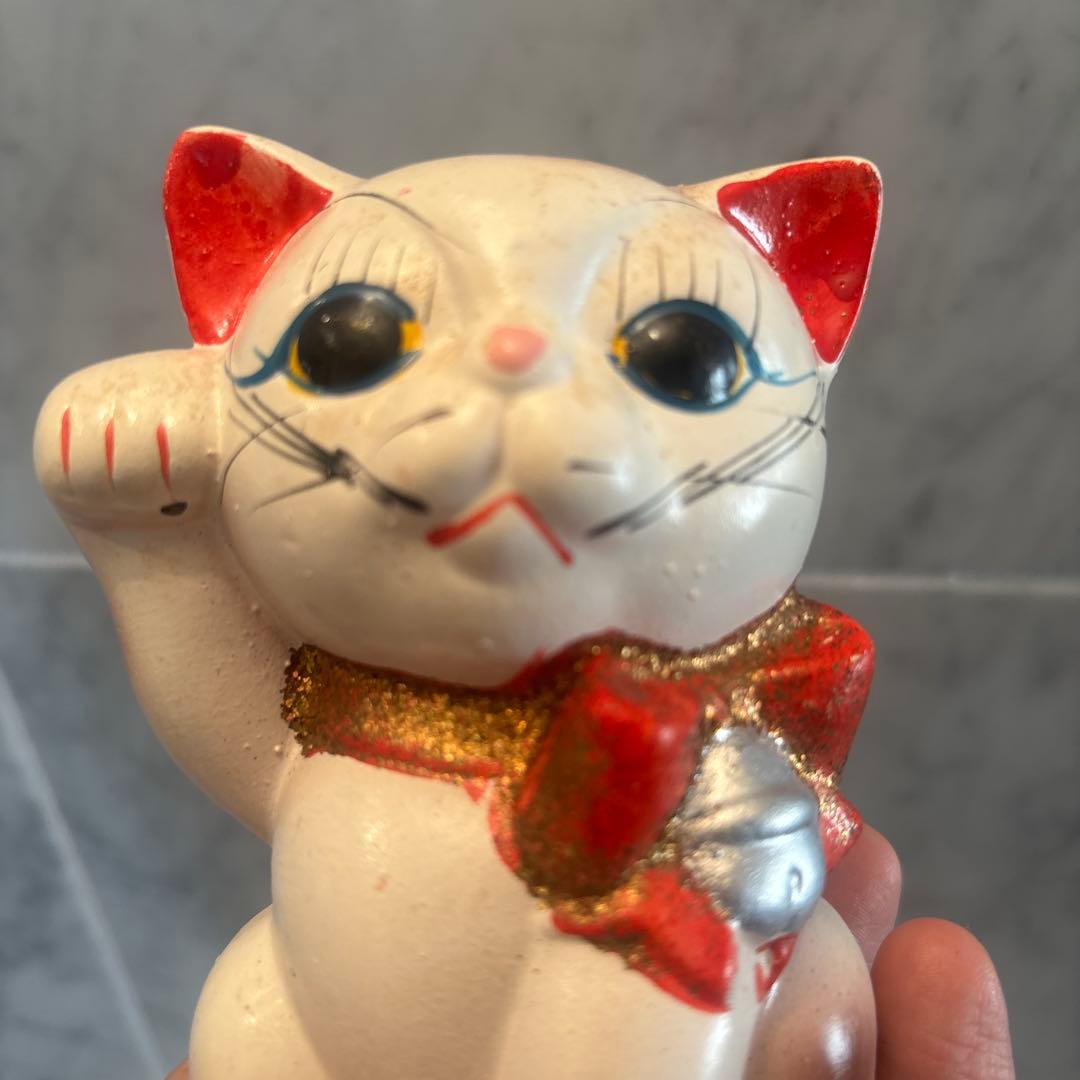 アンティーク大きな瞳や長いヒゲ、まつ毛が美しく、大きなリボンも可愛い招き猫